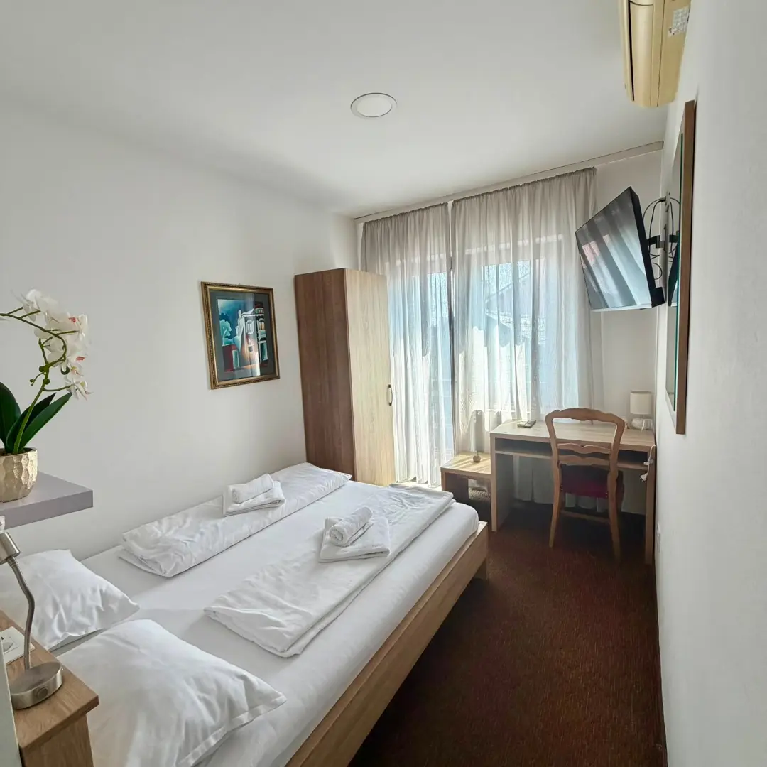 Svijetla dvokrevetna soba s radnim stolom / Bright double room with a desk